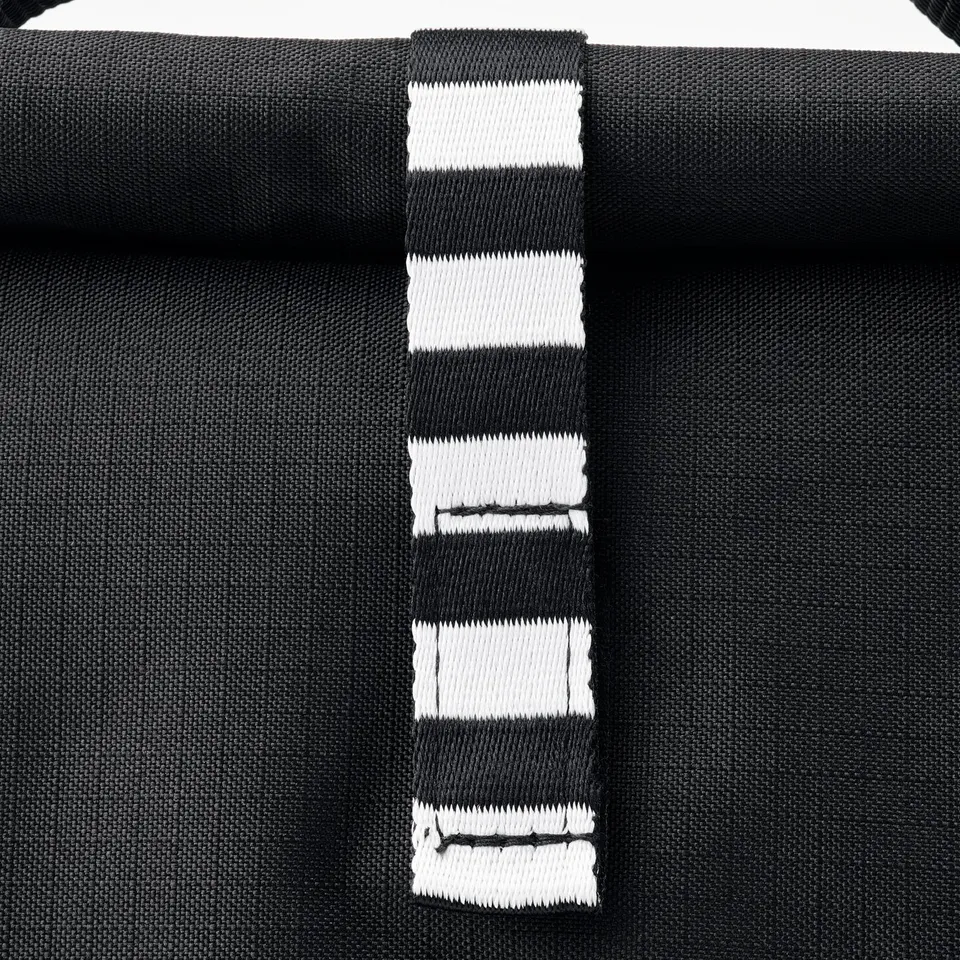 Black striped bag with sturdy handles displayed closely, showcasing its quality texture and design.