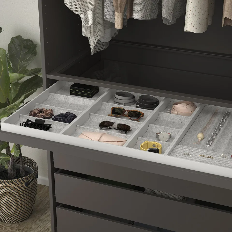 Organised jewellery tray with compartments for rings, necklaces, and watches in a drawer.