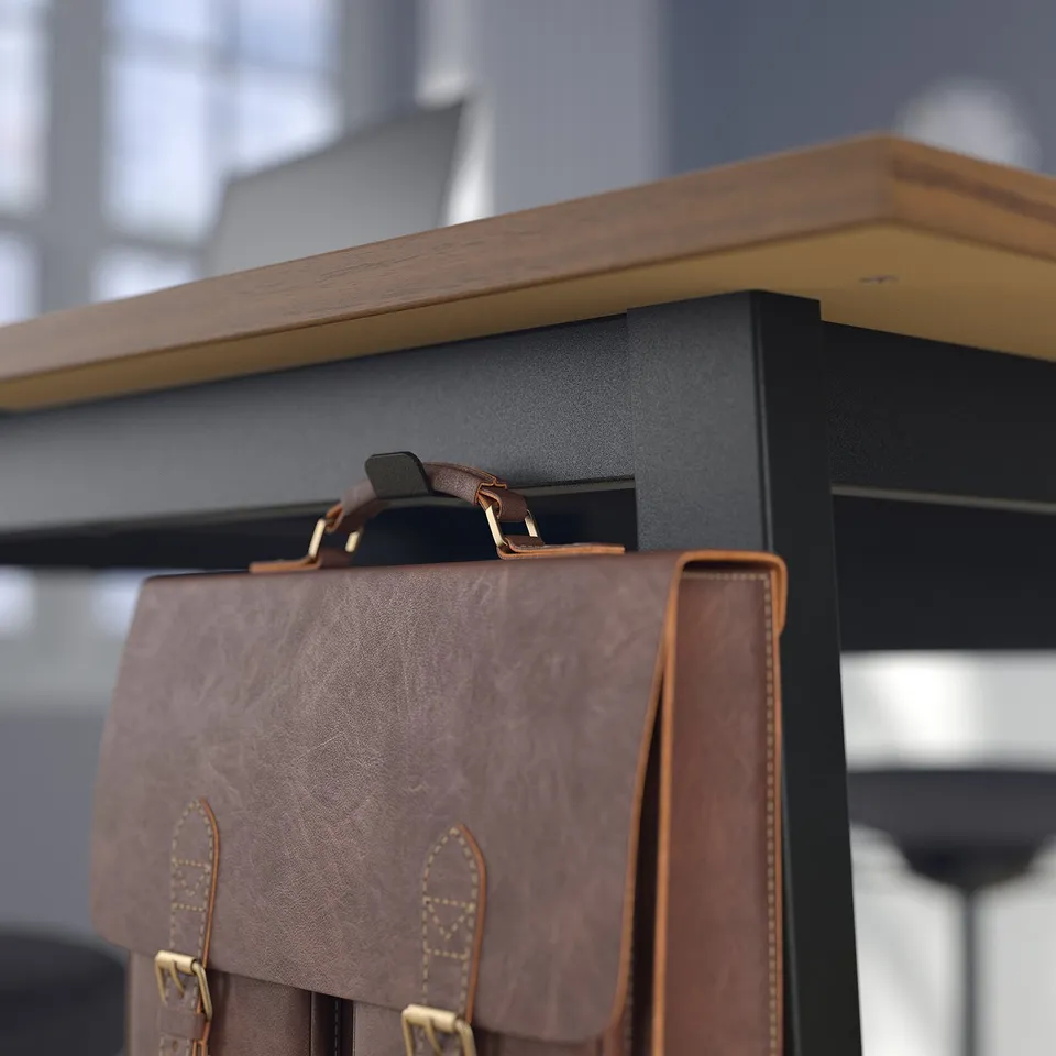 Brown leather bag hangs on black table,