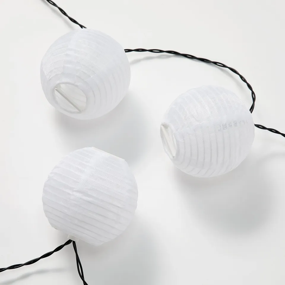 Three white lanterns hang in line, creating soft ambiance.