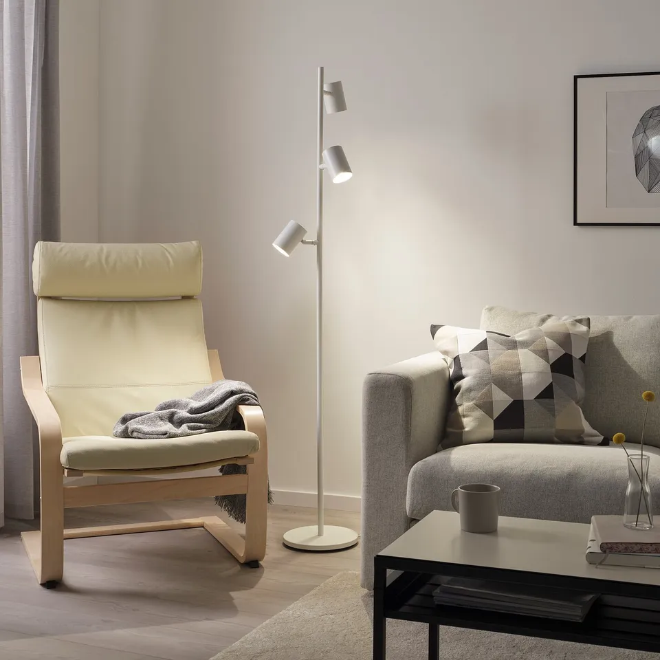 Modern living room with NYMÅNE lamp beside a rocking chair and sofa.