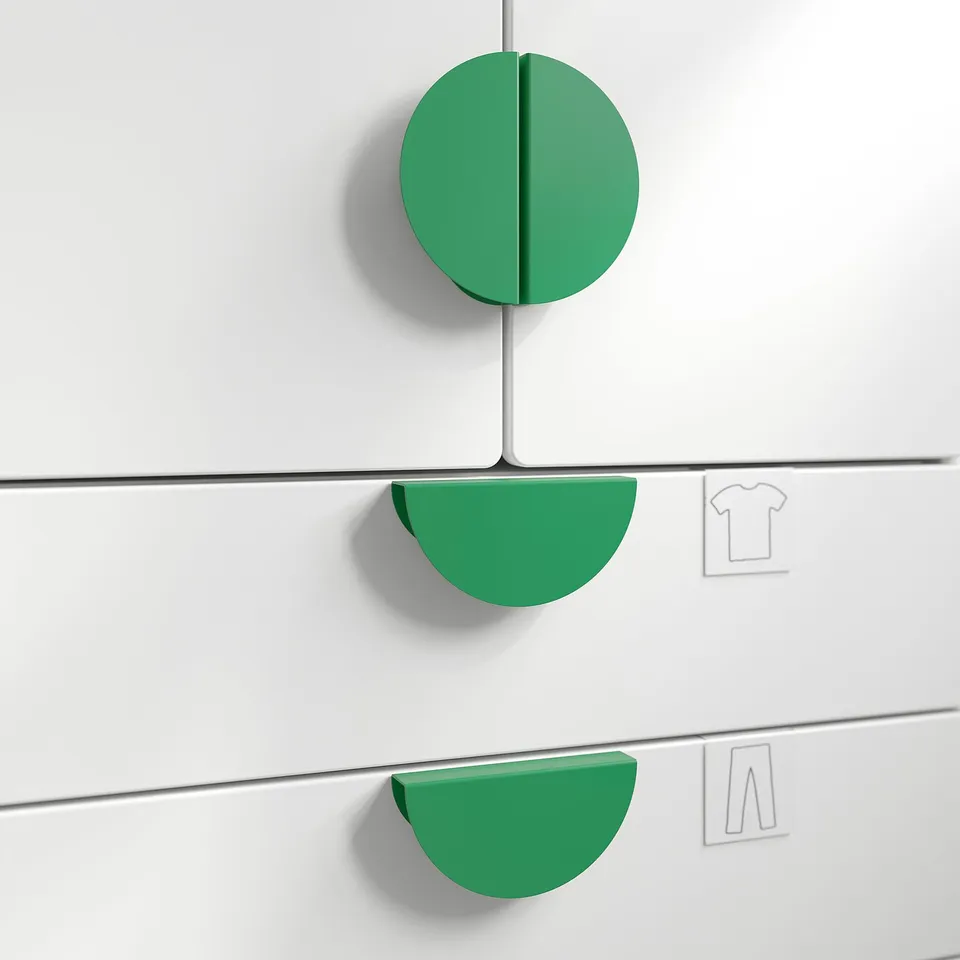 Three green circular knobs on white drawers, perfect for gripping and adding colour.
