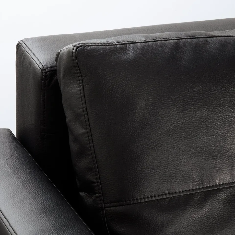 Black sofa armrest with stitching detail.
