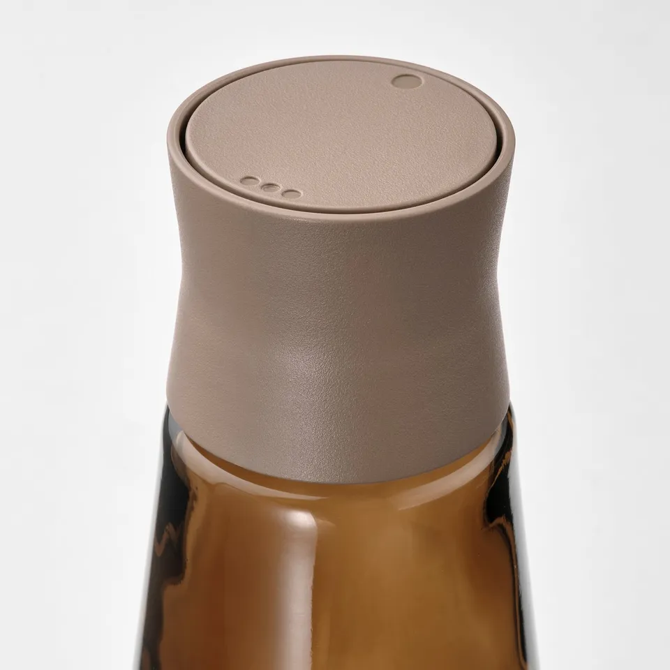 Stylish amber glass jar with brown cap, ideal for kitchen.