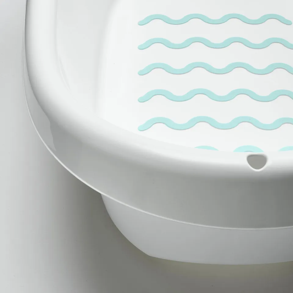 Baby bath with soft edges and anti-slip bottom. Light blue wave patterns, stable design.