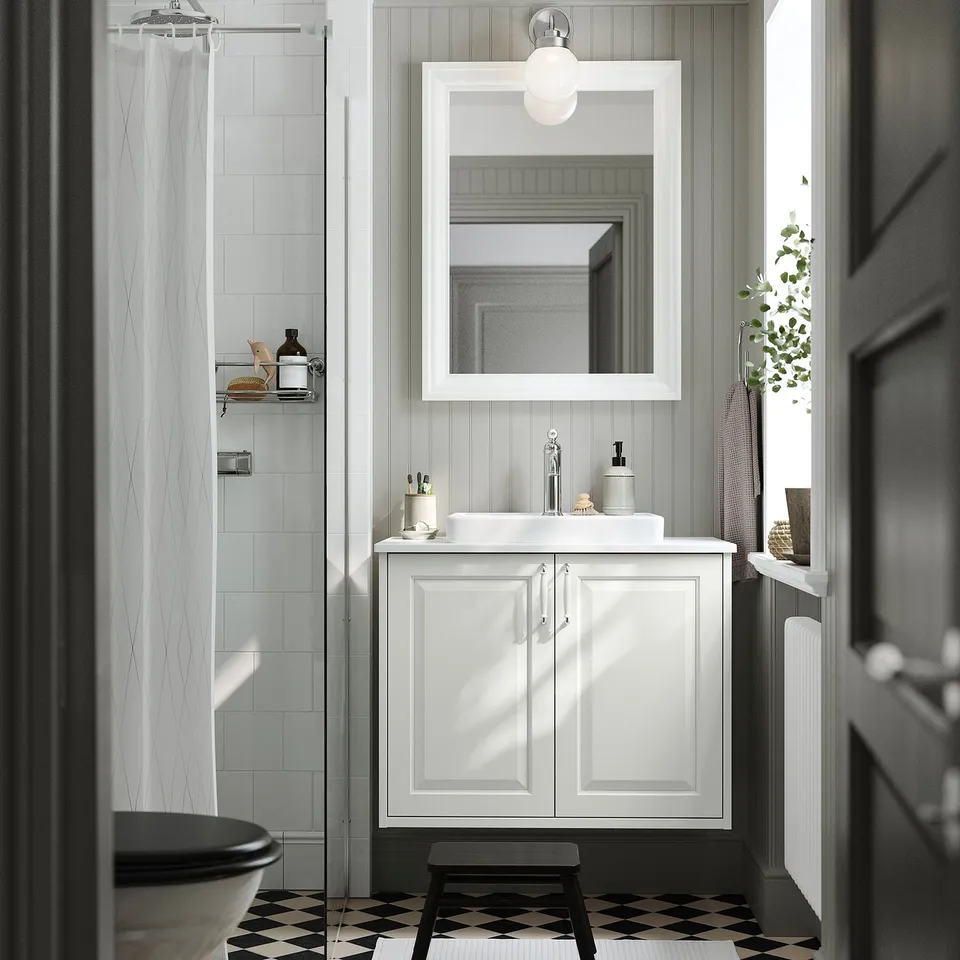 White TÄNNFORSEN vanity with mirror, sink, and window.
