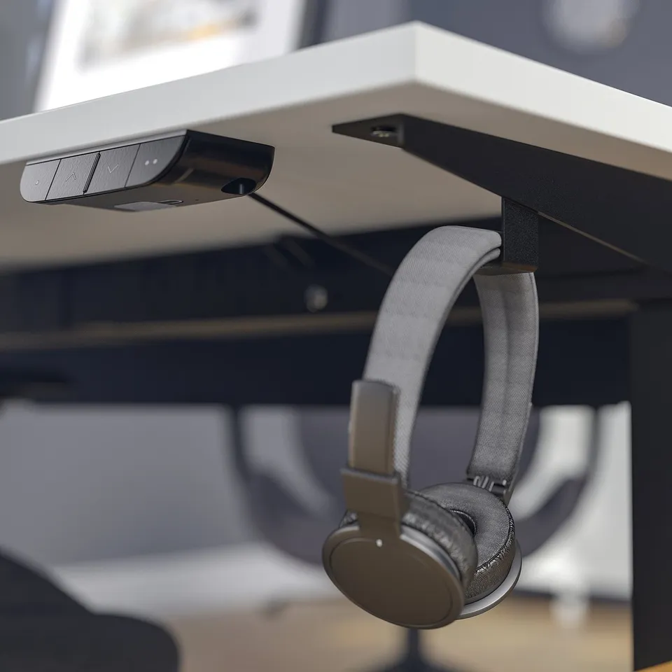 It shows a desk with motorised height control and headphones hook.