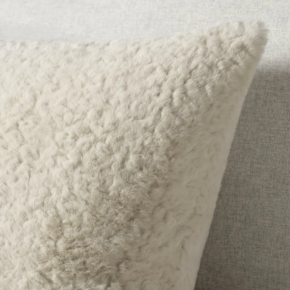 Fluffy beige cushion, soft texture, inviting touch, recycled polyester.