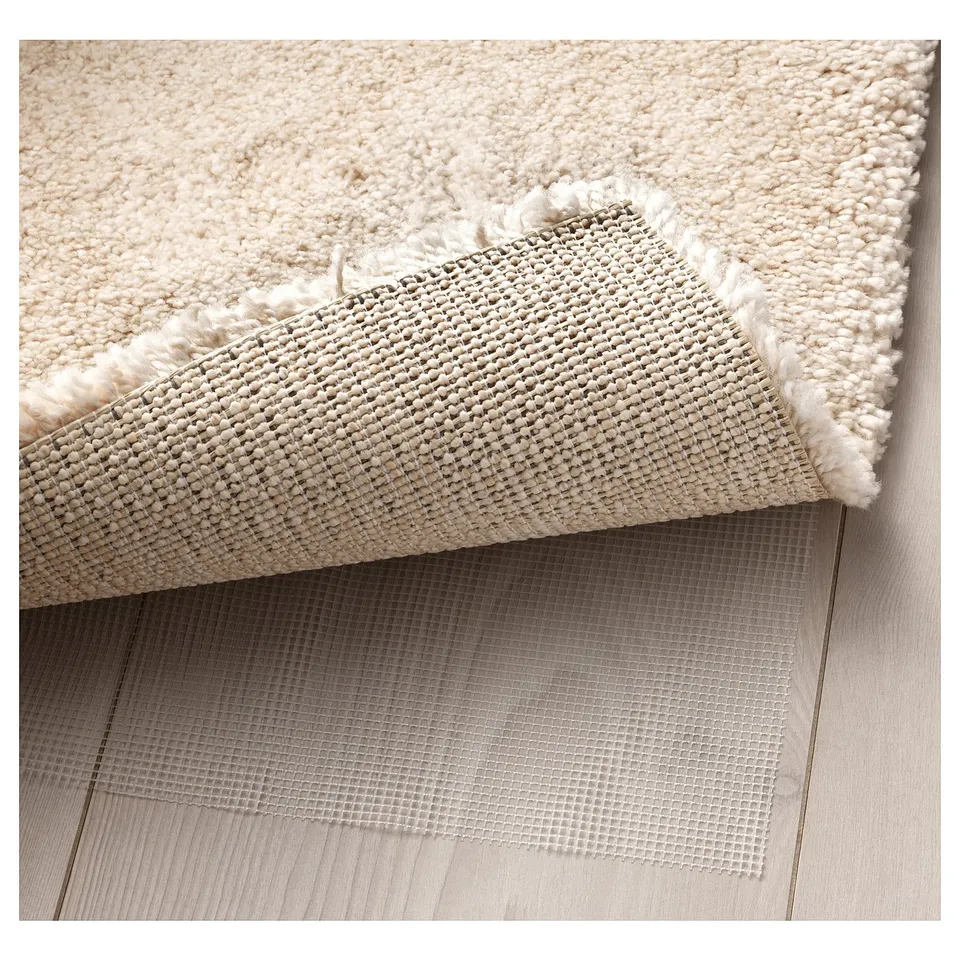 Thick, soft rug with mesh underlay. Edges show dense pile and anti-slip texture.