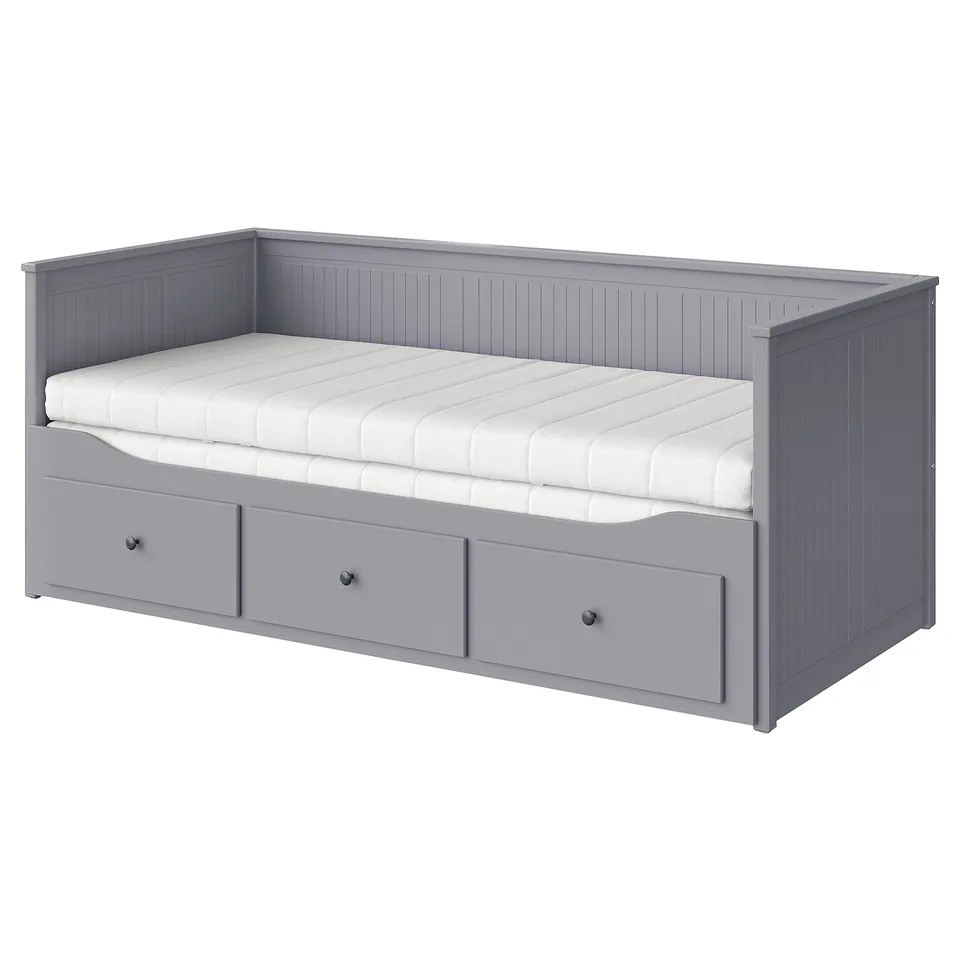 A grey HEMNES day-bed with a foam mattress, three drawers for storage, and a wooden frame.