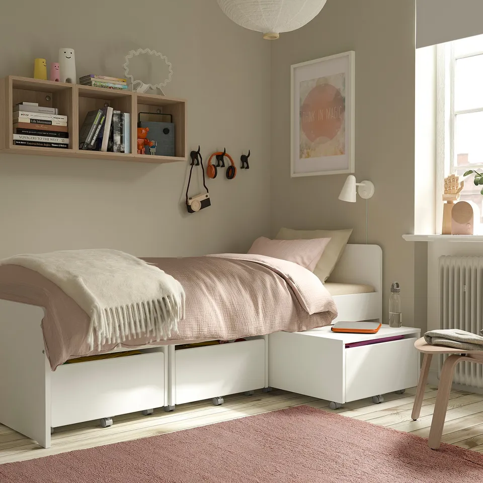 Bedroom with STOENSE rug, light pink, rectangular, soft low pile, under single bed, next to side table.