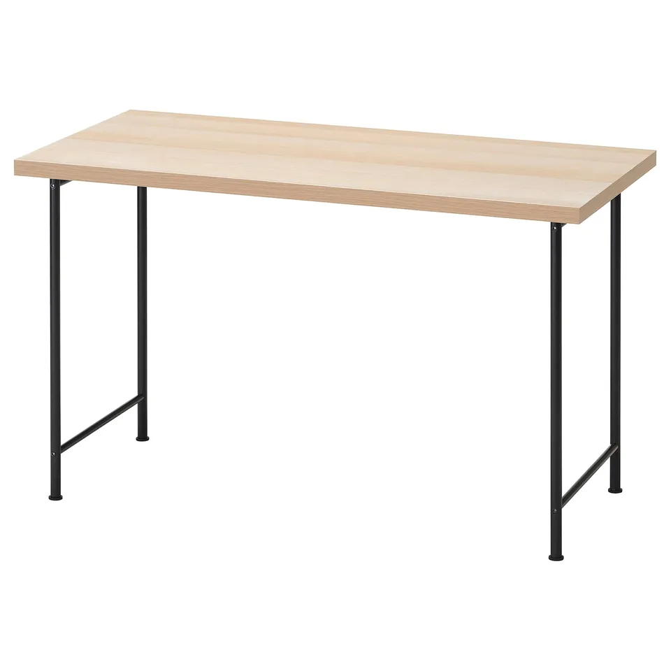 A light-colored wooden desk with black metal legs. It has a rectangular top and is supported by four angled legs.