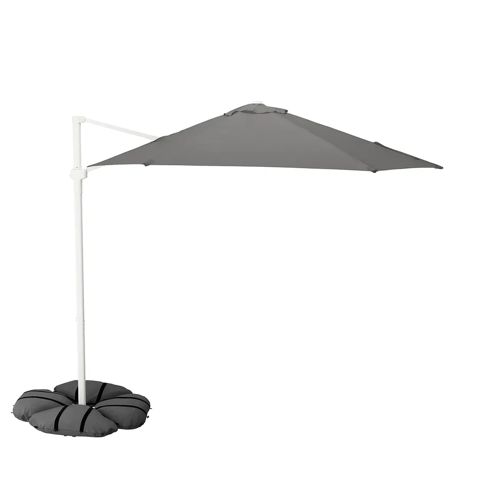 HÖGÖN grey parasol with white pole, sun-protected, wind-resistant, supported by soft sandbags.