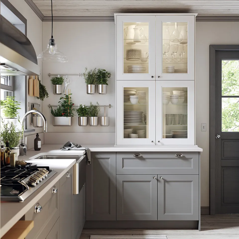Grey kitchen with glass cabinets, white dishes, led lights, hanging planters, gas stove by windows.