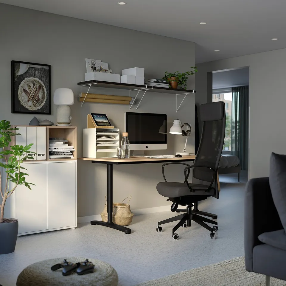 Modern home office with EKET storage units, sleek desk, black chair, imac, shelves with decor, and cosy grey carpet.