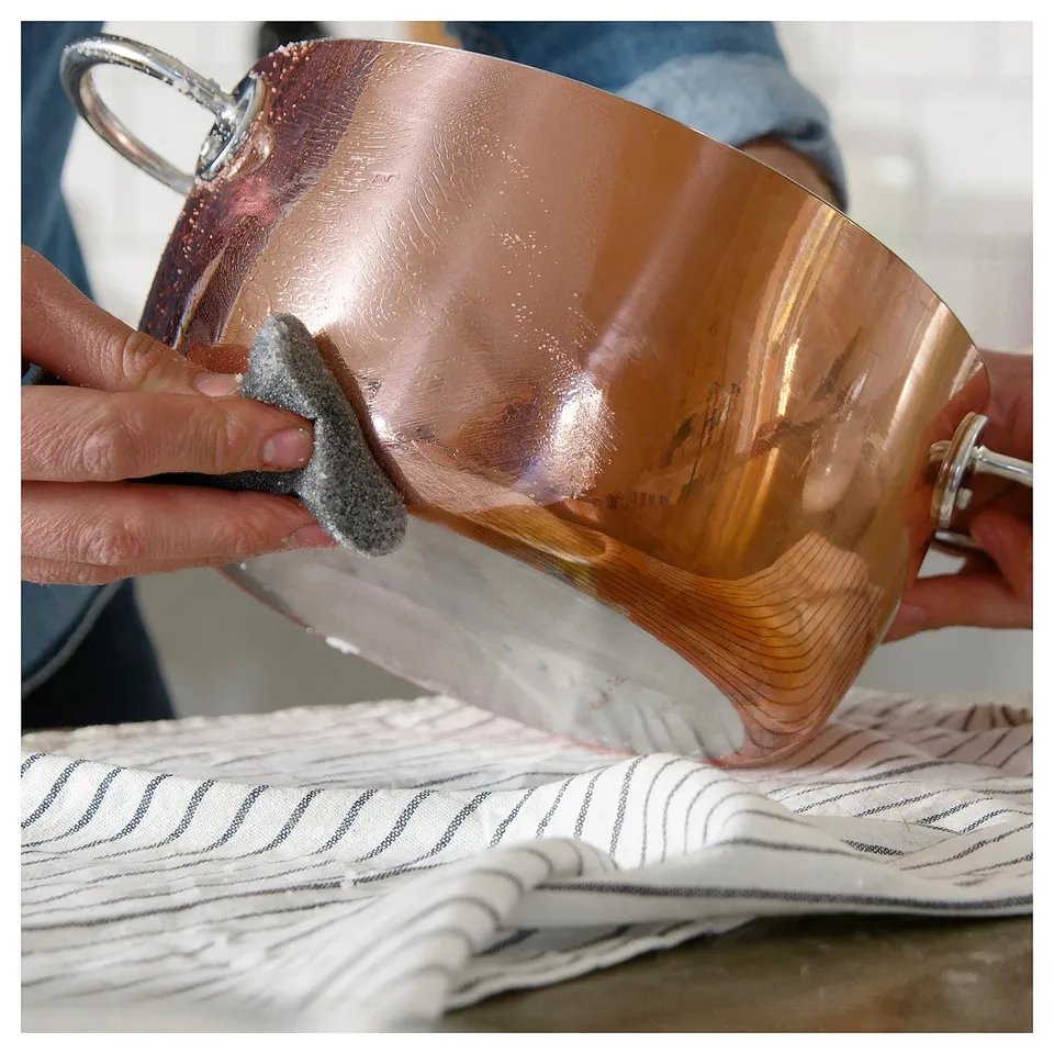 Cleaning coppot with sponge.