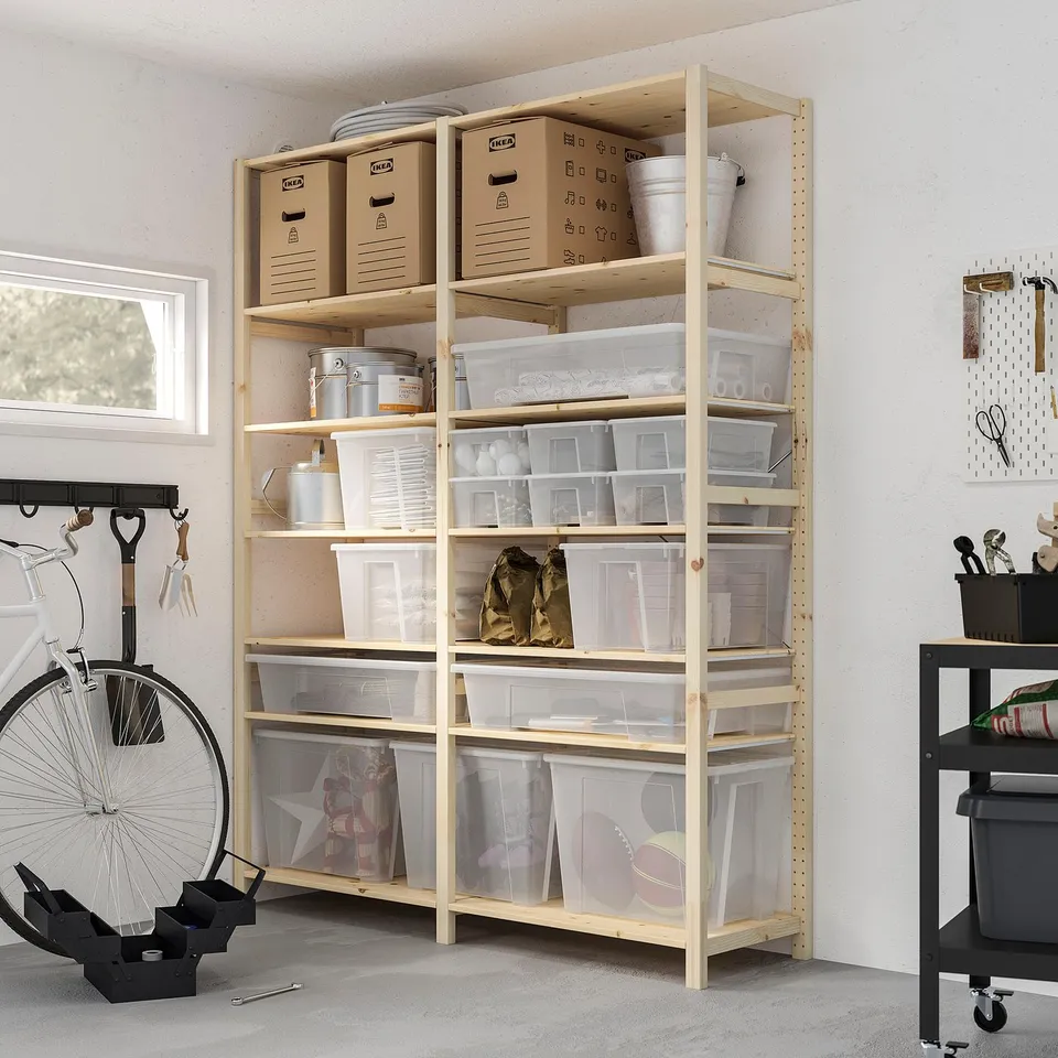 Wooden shelf with SAMLA boxes storing sports gear, tools, and cleaning supplies. Bicycle on left, trolley on right.