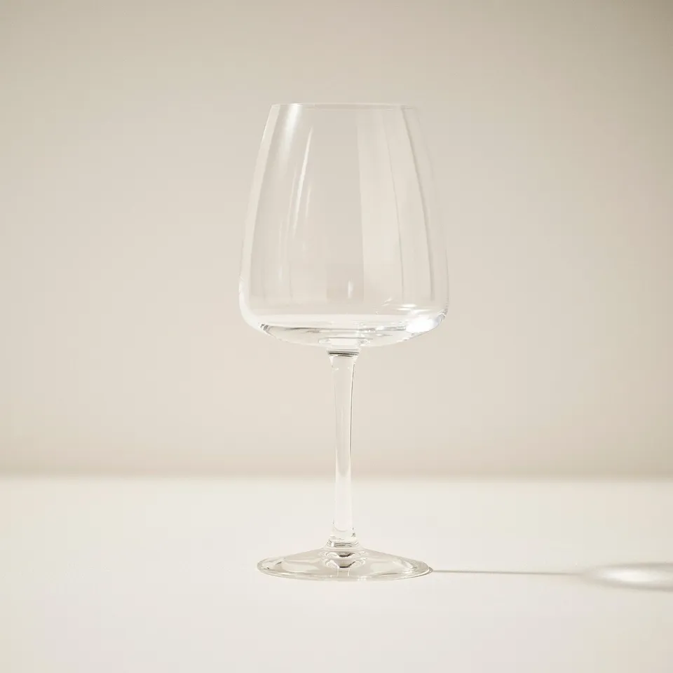 Elegant wine glass on plain background, showing transparency and design.