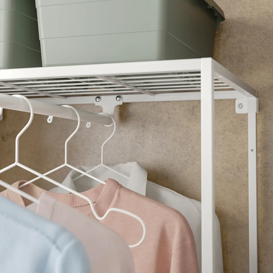 White metal closet organiser, hanging clothes on hooks, efficient closet space.
