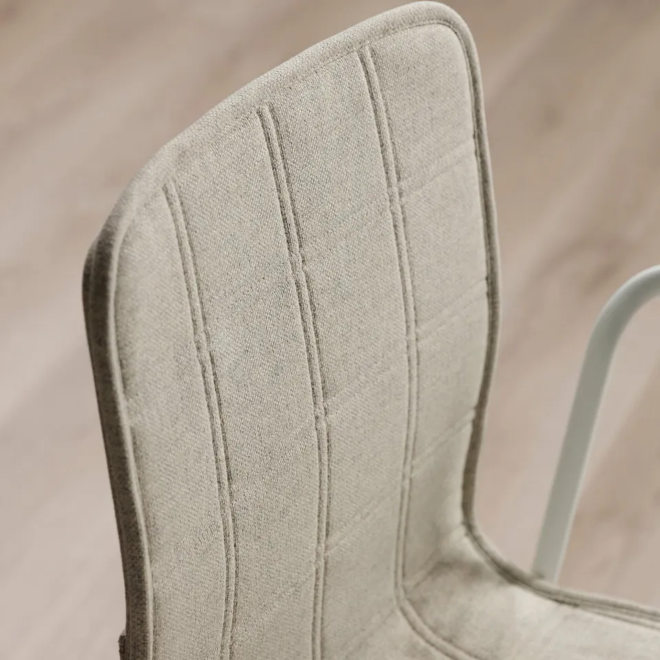 Close-up of modern office chairs cushioned back, showcasing quality stitching and fabric.