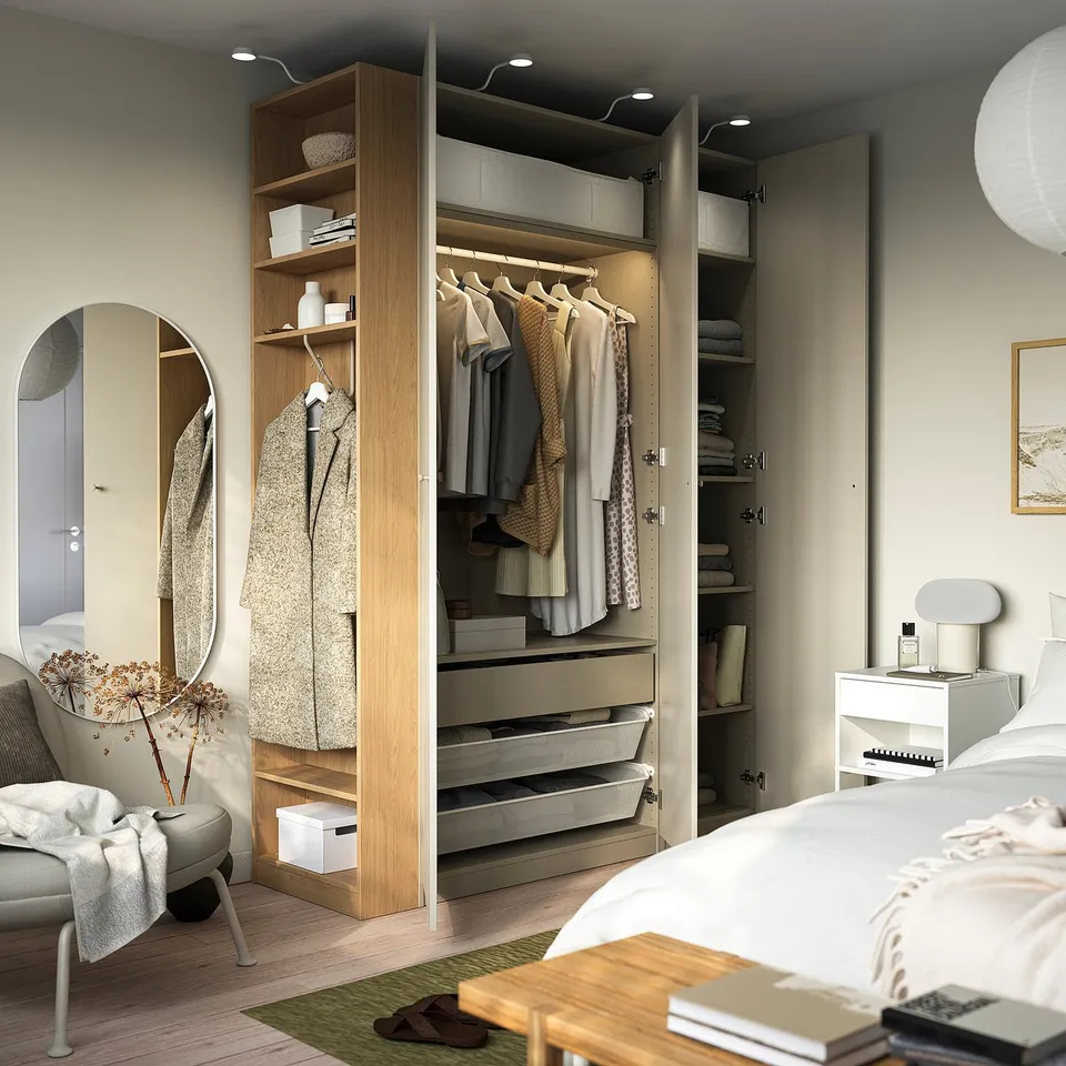 Modern wardrobe with open/closed storage, lights, in organised bedroom.