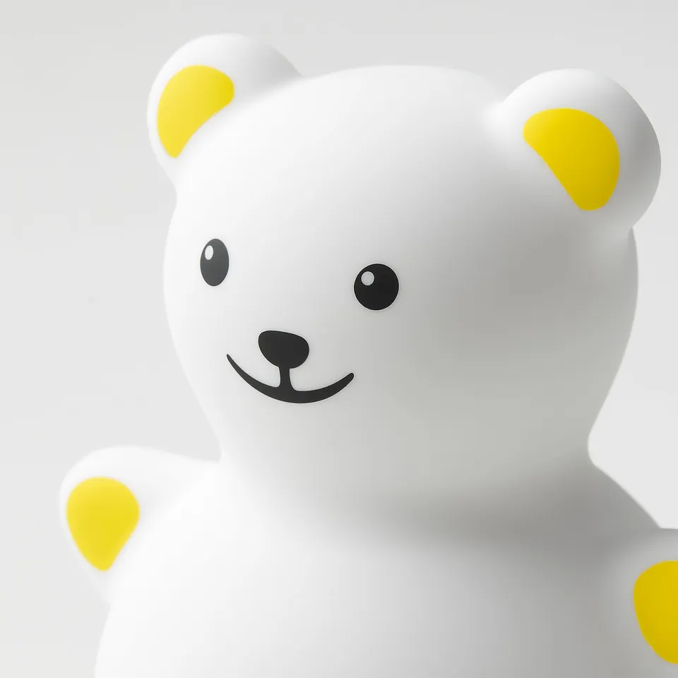 A sleek, smooth, friendly-looking white teddy bear night light with bright yellow details, designed for kids.