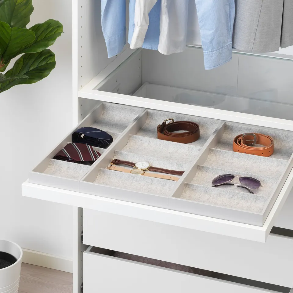A white wardrobe organiser with a pull-out tray holding accessories.