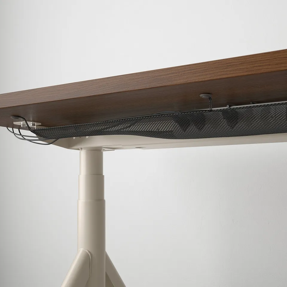 Desk with cable management net and height adjustment handle.