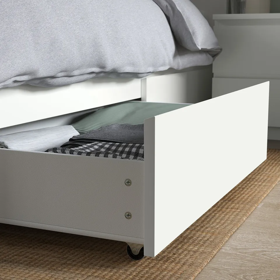 Bed frame with open drawer showcasing neatly folded blankets, demonstrating easy accessible storage.