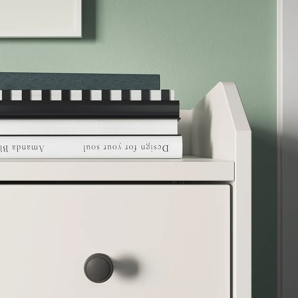 A white HAUGA bedside table with books on top,