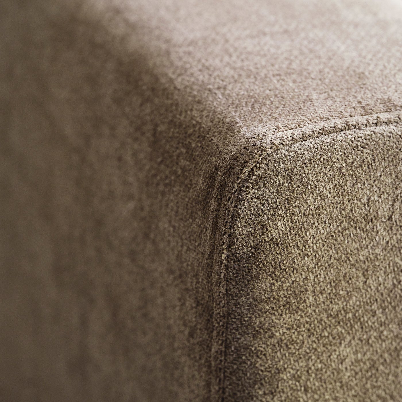 Close-up of soft, textured fabric, likely from a high-quality sofa, showcasing intricate weave and subtle sheen.