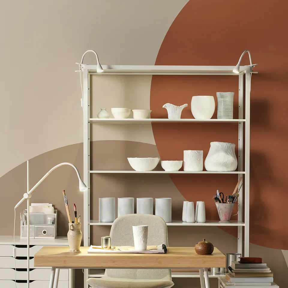 Bamboo desk with chair, stylish white bookshelf, earth tone walls.