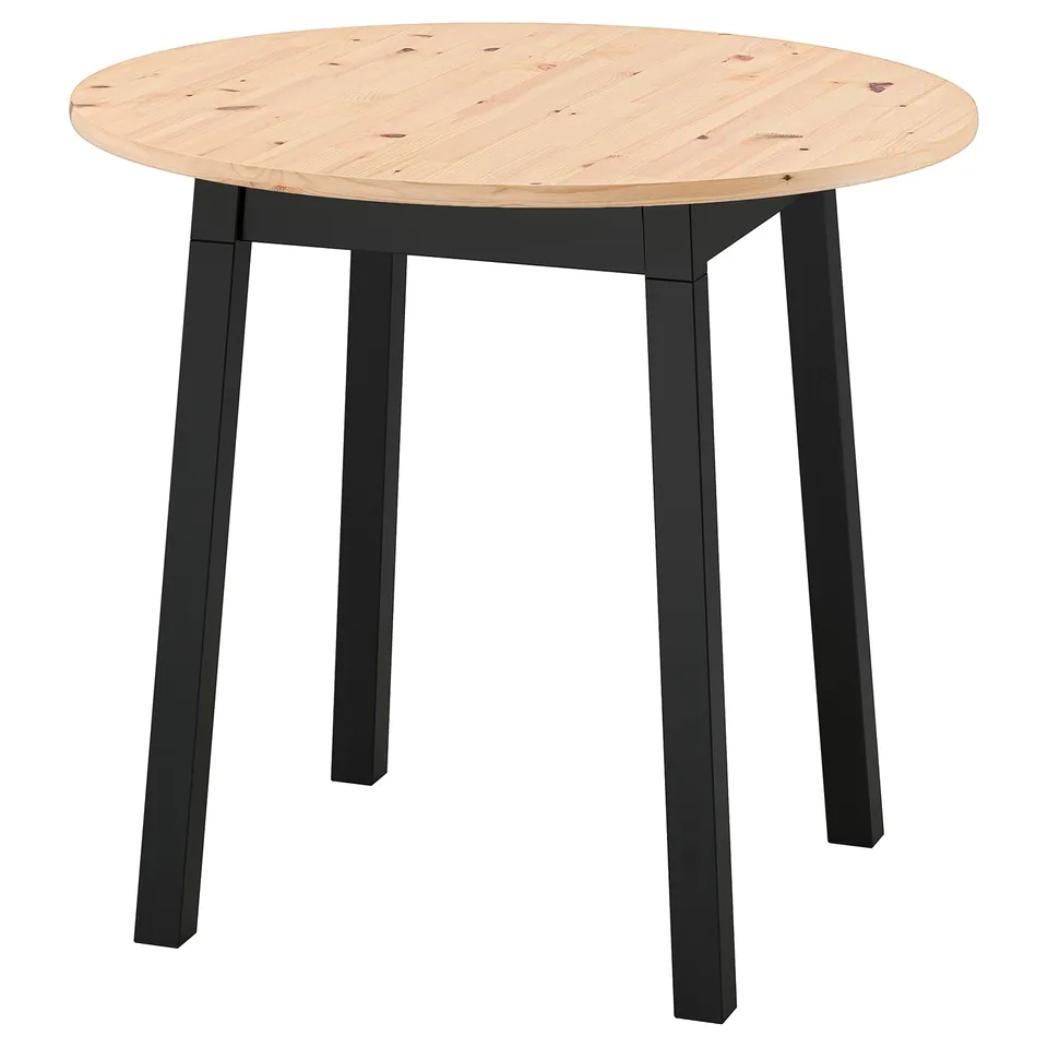 An IKEA pintorp table. It is round, light-colored, with black legs and a wooden top. The design is simple and modern.