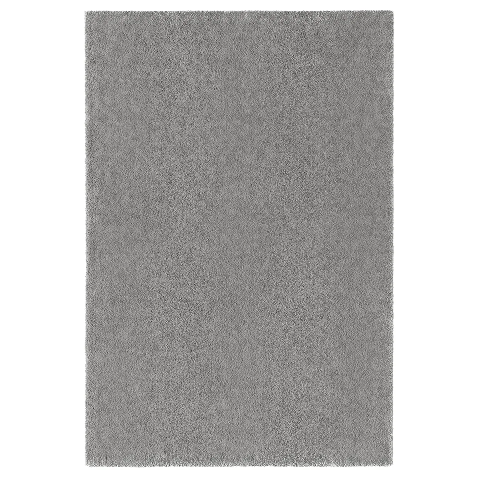 A rectangular grey STOENSE rug made of polypropylene, with a soft, thick pile.