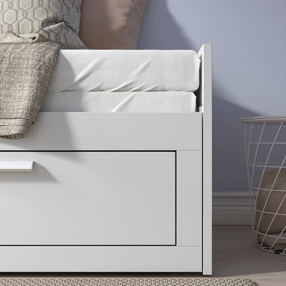 Day-bed with drawn mattresses, pillows, and drawers for bedding storage. Shows dual functionality as sofa and bed.