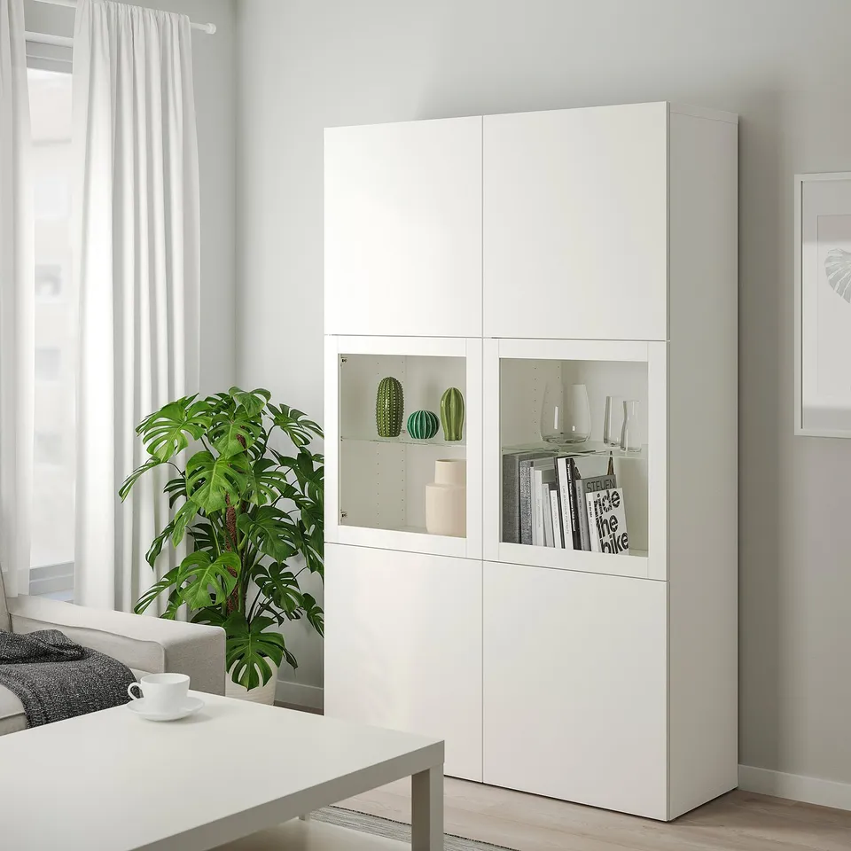 BESTÅ cabinet with glass doors, plant, coffee table, couch, art.