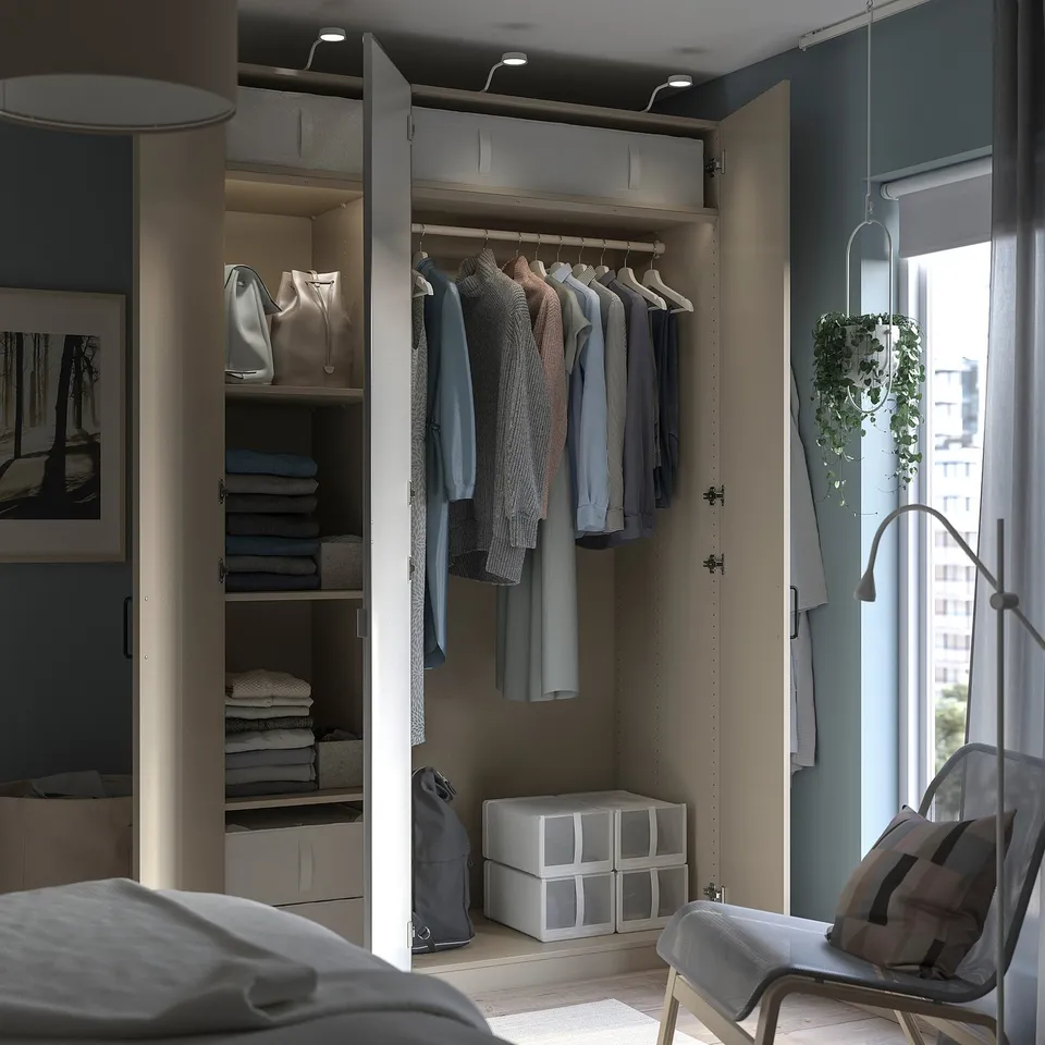 Modern bedroom featuring a PAX wardrobe with organised clothes, shelves, mirrors, and white decor.