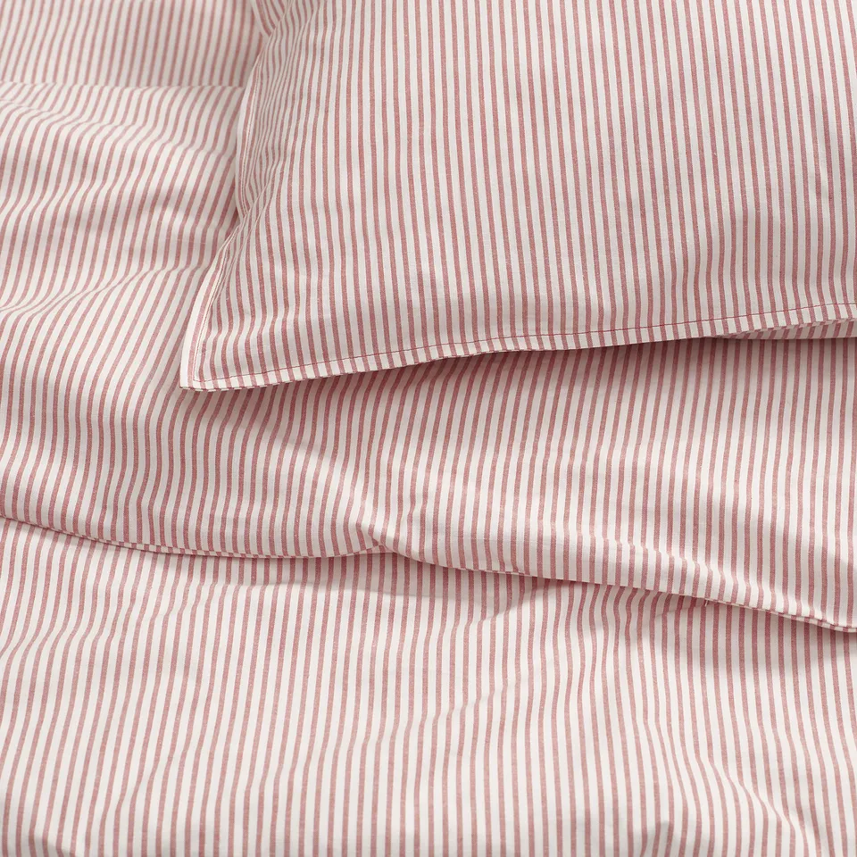 Striped bedding with fine lines, likely made from soft, woven 100% cotton, folded neatly, showing smooth texture.