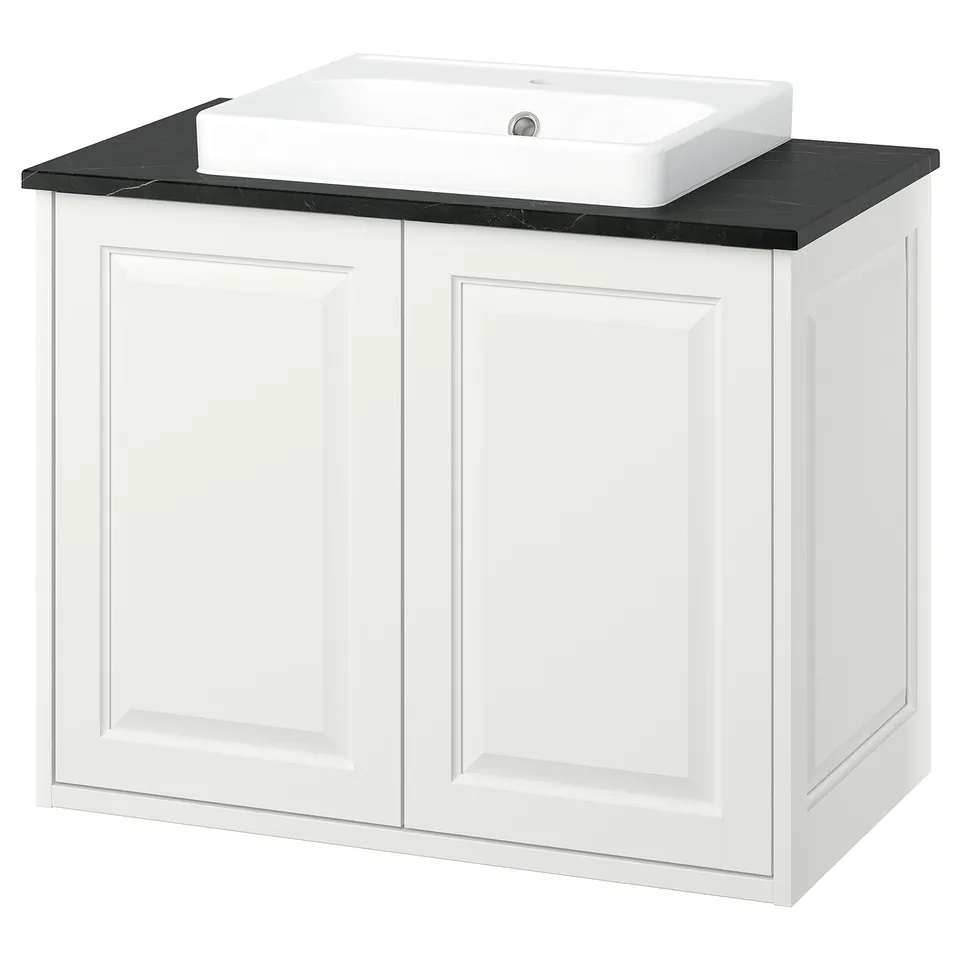 White bathroom vanity, two doors, black countertop, rectangular sink.