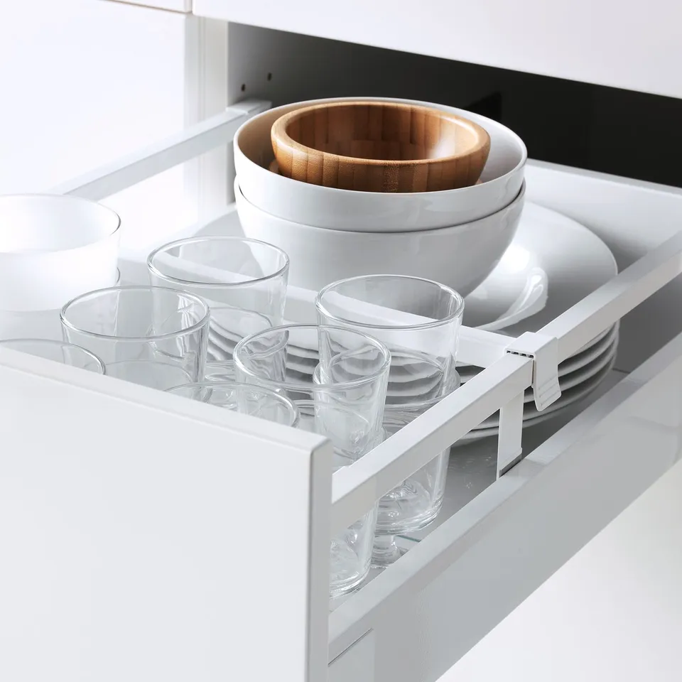 Kitchen drawer with glasses and bowls, featuring adjustable shelves and smooth, soft-close mechanism.