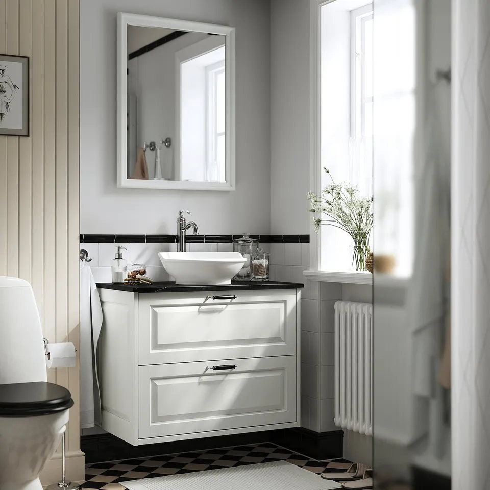 Modern bathroom featuring TÄNNFORSEN white vanity with square sink, mirror, toilet, and radiator. Classic design with ample storage.