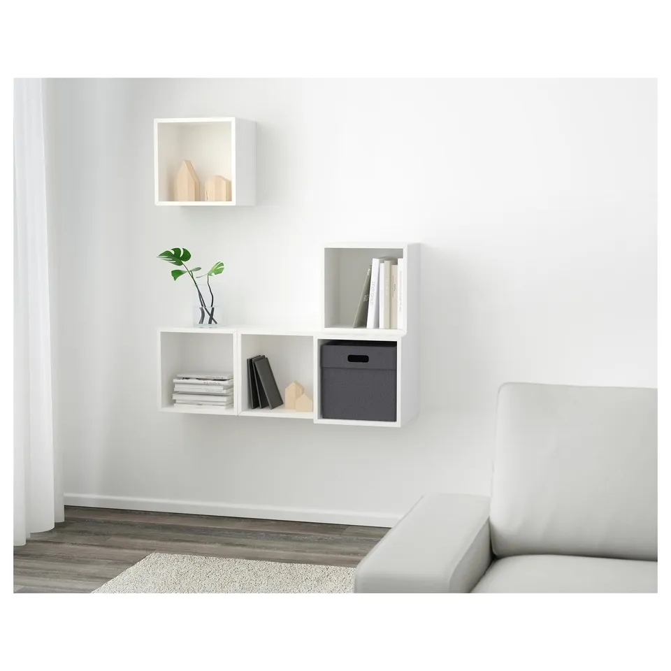 Minimalist wall-mounted shelves, both open and closed, hold books, plants, and decor, offering storage and displaying items neatly.