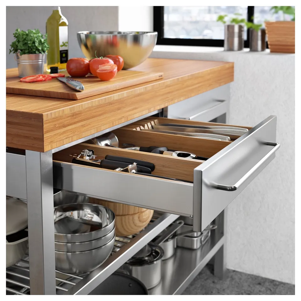 A RIMFORSA kitchen island made with bamboo, steel, and glass; featuring drawers, shelves, and hooks for storage.