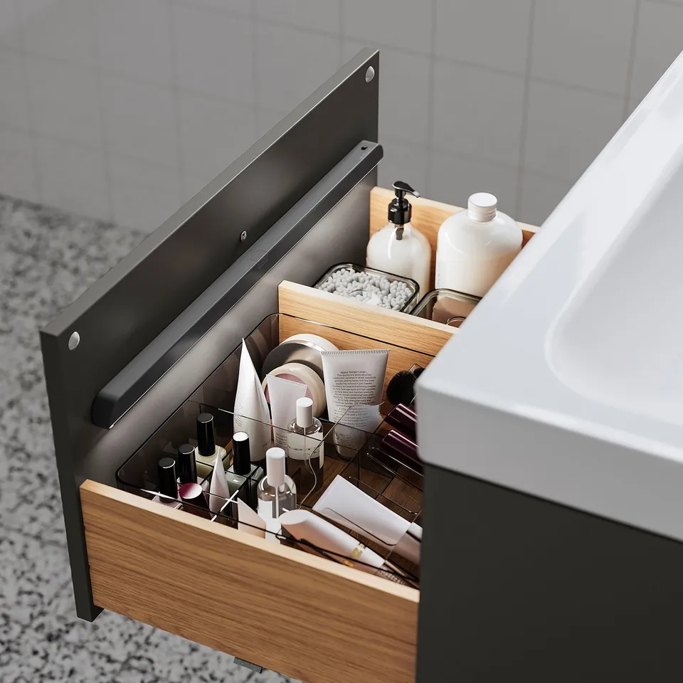 Open bathroom drawer with organised toiletries: lipsticks, bottles, and cotton.
