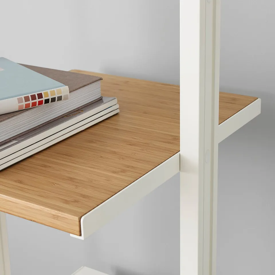 Wooden shelf with white metal brackets, holding stacked books. Part of ELVARLI storage system.