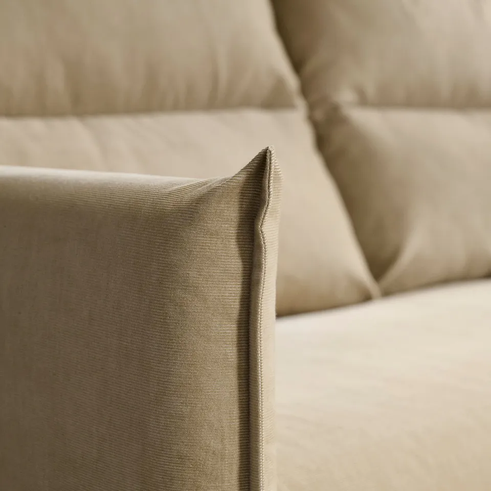 Neutral-toned sofa with plush cushions, showcasing comfortable and elegant design.