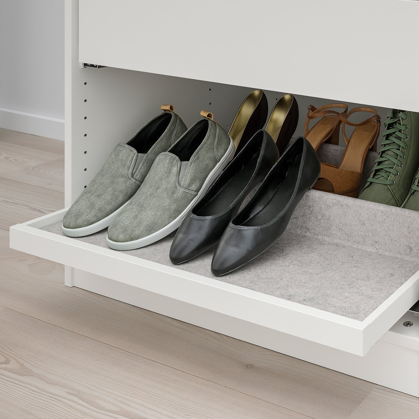 White shelf holding several pairs of shoes on felt inserts for organised display.