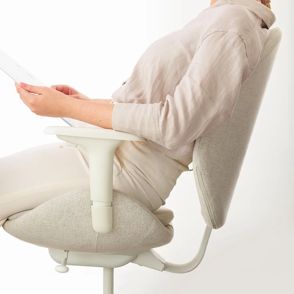 Person sitting in an office chair, using a tablet. The chair has a synchronised tilt mechanism and adjustable backrest.
