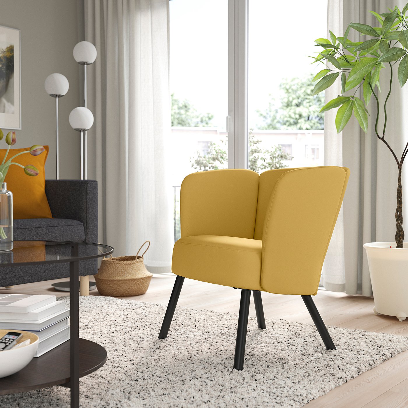 Cosy living room with yellow HERRÅKRA armchair, modern decor. Bright lemon upholstery, black legs, large window, grey couch, plants, rug.
