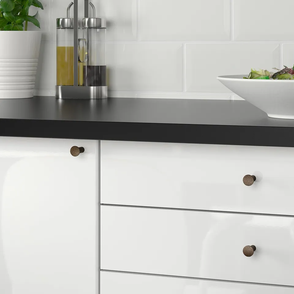 Kitchen drawer with bronze knob, holding plates and salad.
